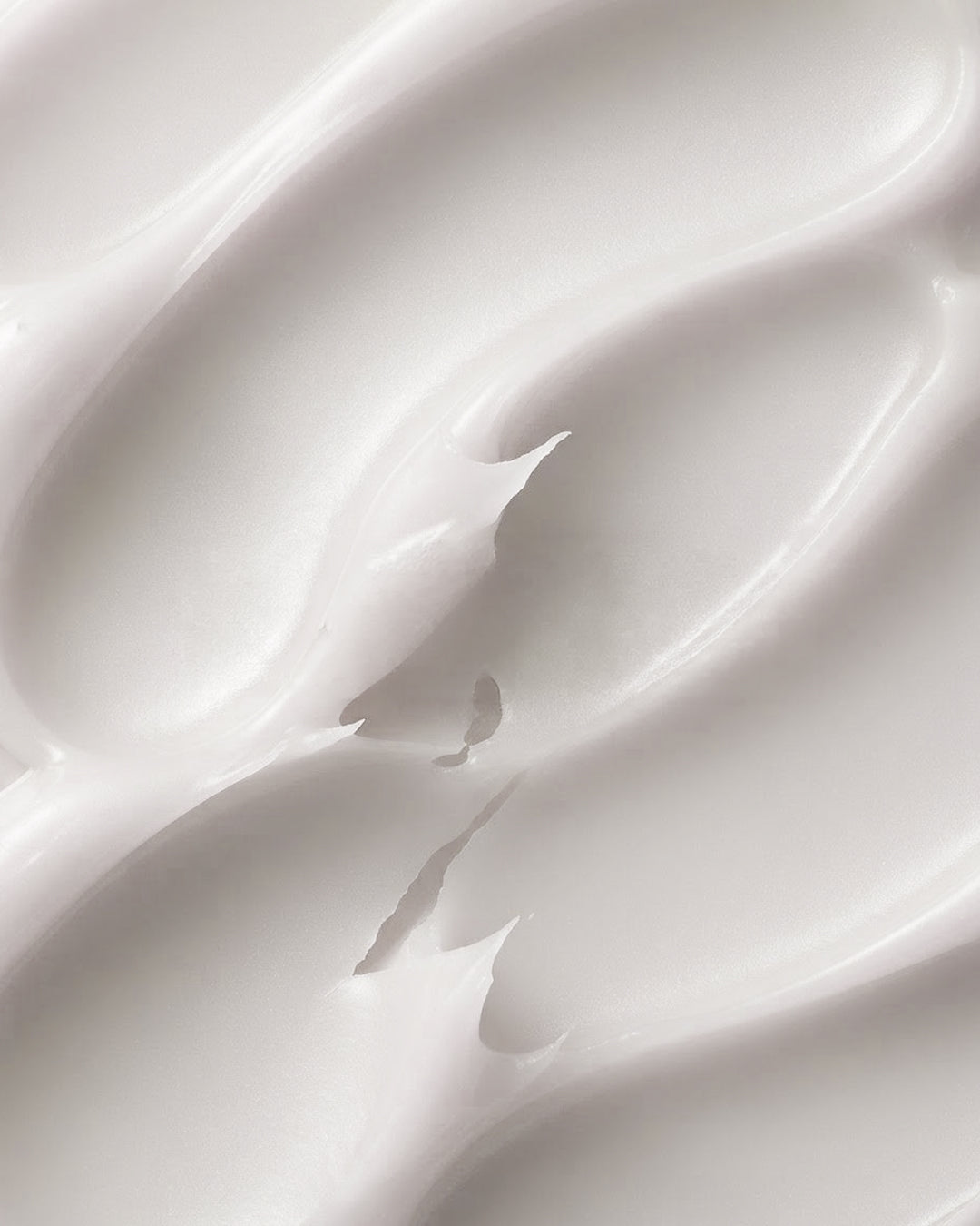 Texture de crème de soin en gros plan, matière blanche nacrée et sillons profonds